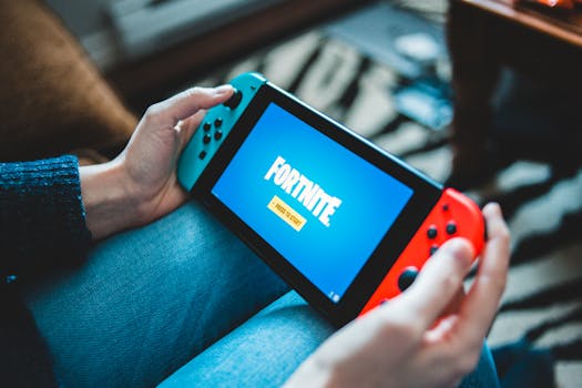 Close-up of hands holding a Nintendo Switch with Fortnite game screen indoors.